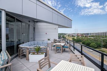 A patio with a table and chairs overlooking a street.at Linc, Iowa, 50309